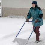 Old man shoveling snow out of his driveway
