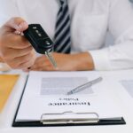 midsection-of-insurance-agent-holding-car-key-at-royalty-free-image-1583601241