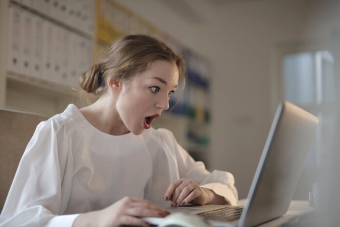 Woman looking at something fascinating on a laptop. Concept for unrealistic bonuses.