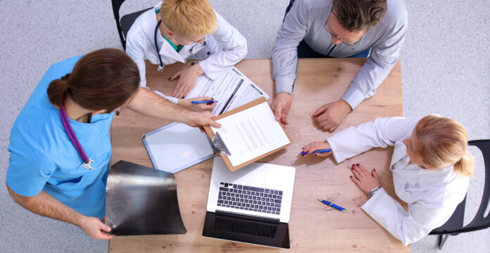 Male and female doctors working on reports in medical office