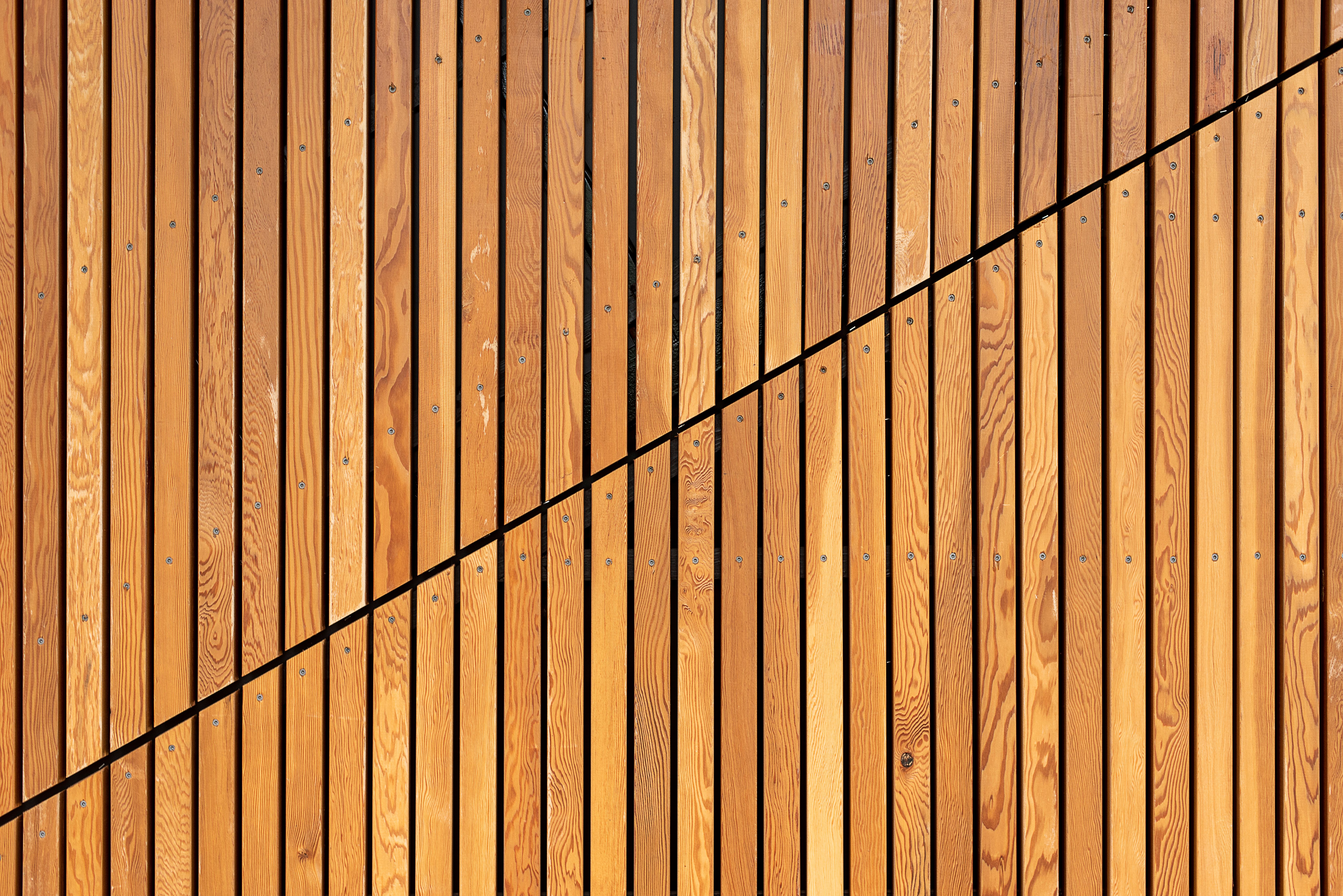 Close-up of modern wooden slats arranged in a contemporary diagonal fence pattern